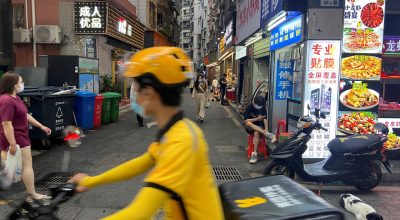 Um entregador de comida passa de bicicleta por uma vila urbana no distrito de Futian, em Shenzhen...