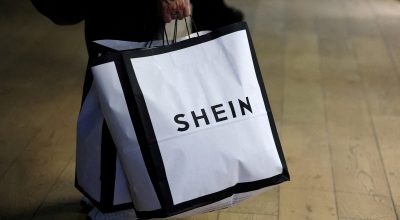 Consumidor segura sacolas de compras com logotipo da Shein em Paris, França