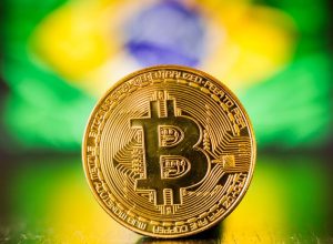 Golden bitcoin coin on Brazil flag as background