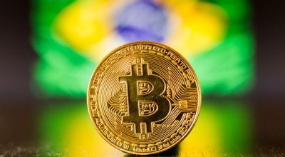 Golden bitcoin coin on Brazil flag as background
